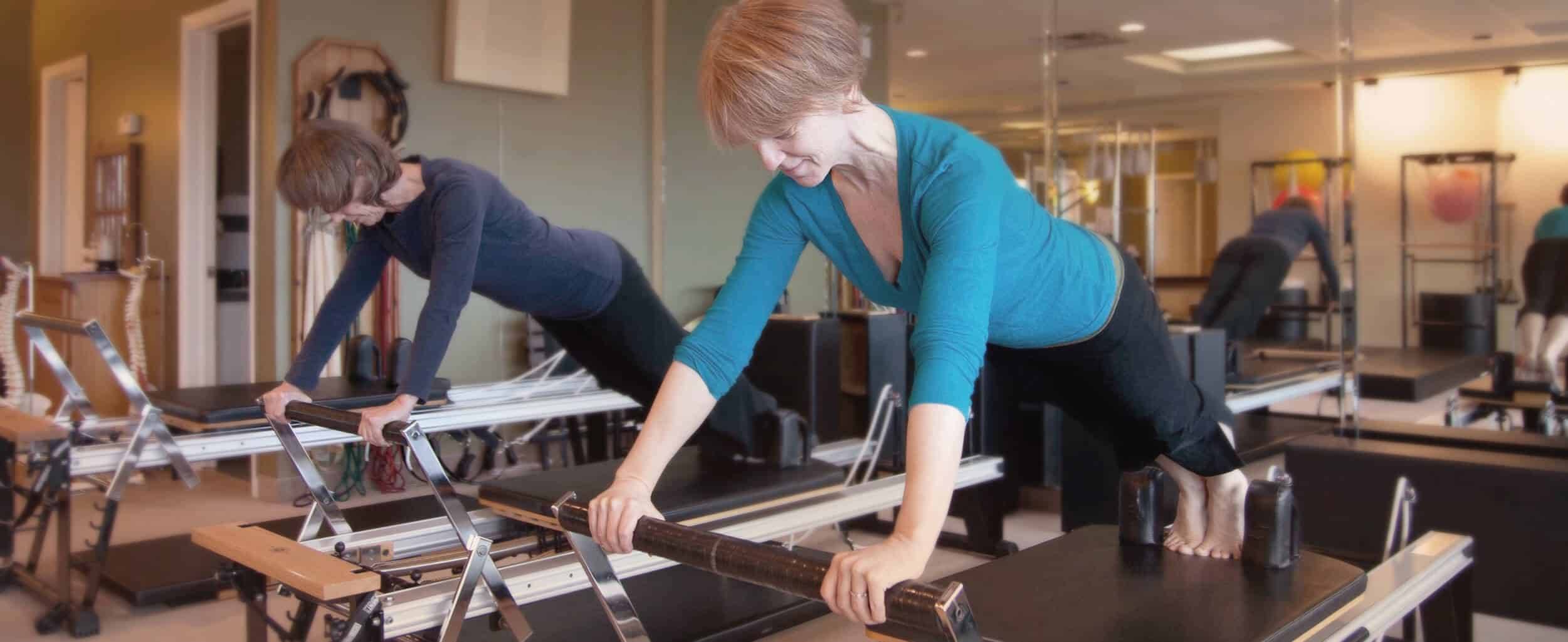 Laura Helsel, Pilates Process owner, and a student demonstrating reformer use.