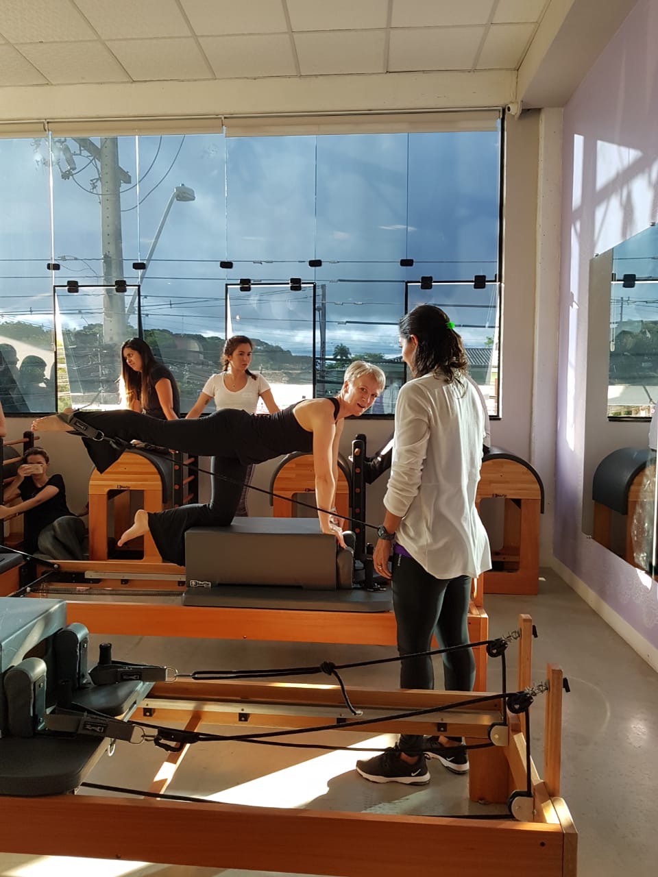 Laura Helsel, Pilates Process Owner, showed teaching a pilates class in a well lit studio, available in Toronto and Vancouver 