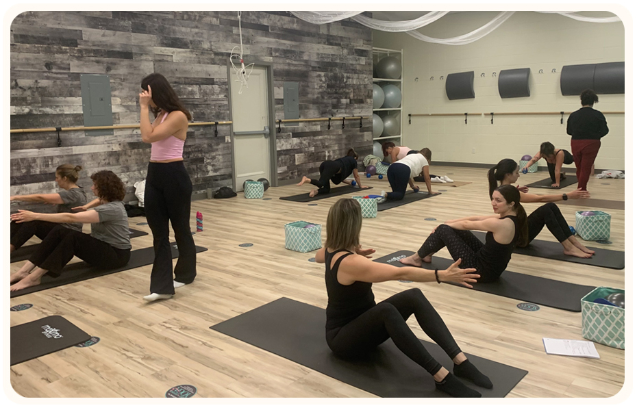 Laura Helsel, Pilates Process Owner, showed teaching a pilates class in a well lit studio, available in Toronto and Vancouver 